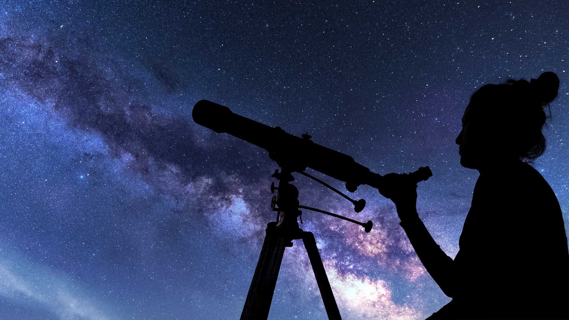 Woman with a telescope observing the night sky